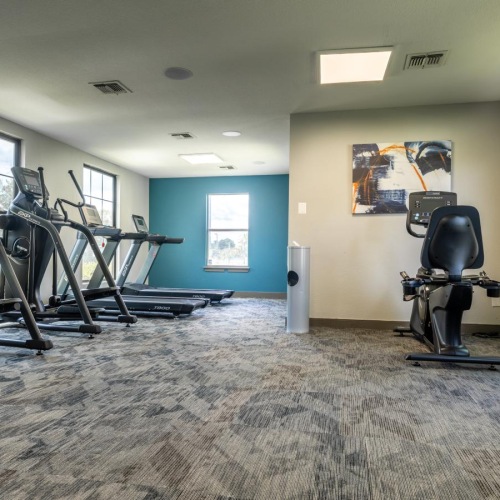Quick access to state-of-the-art amenities a room with treadmills and a rug