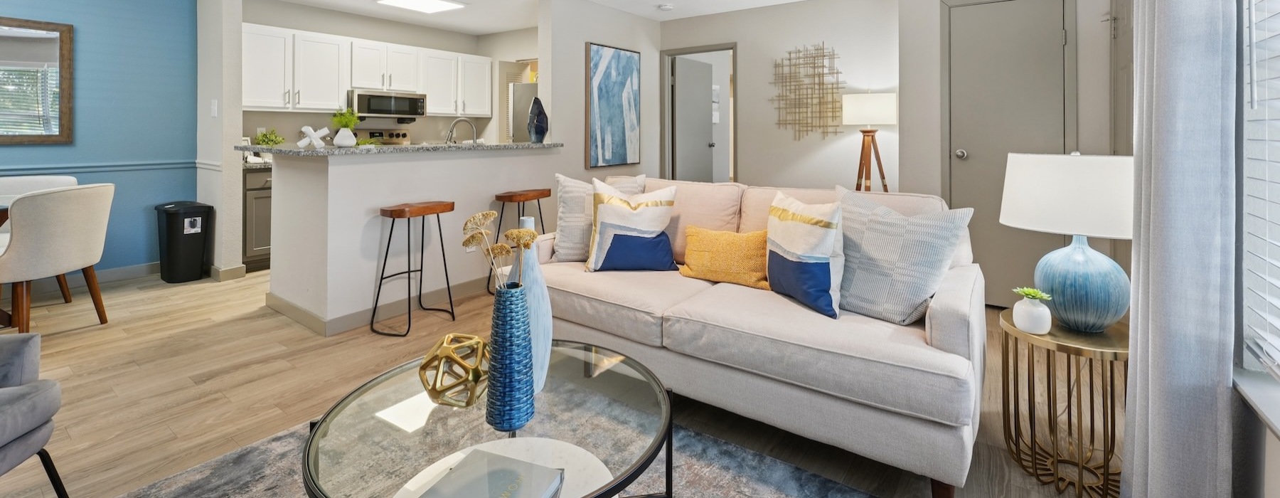 living area with a couch and coffee table and kitchen in the background