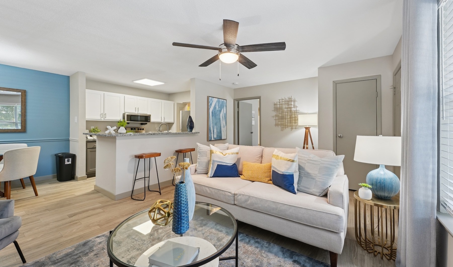 living area with a couch and coffee table and kitchen in the background
